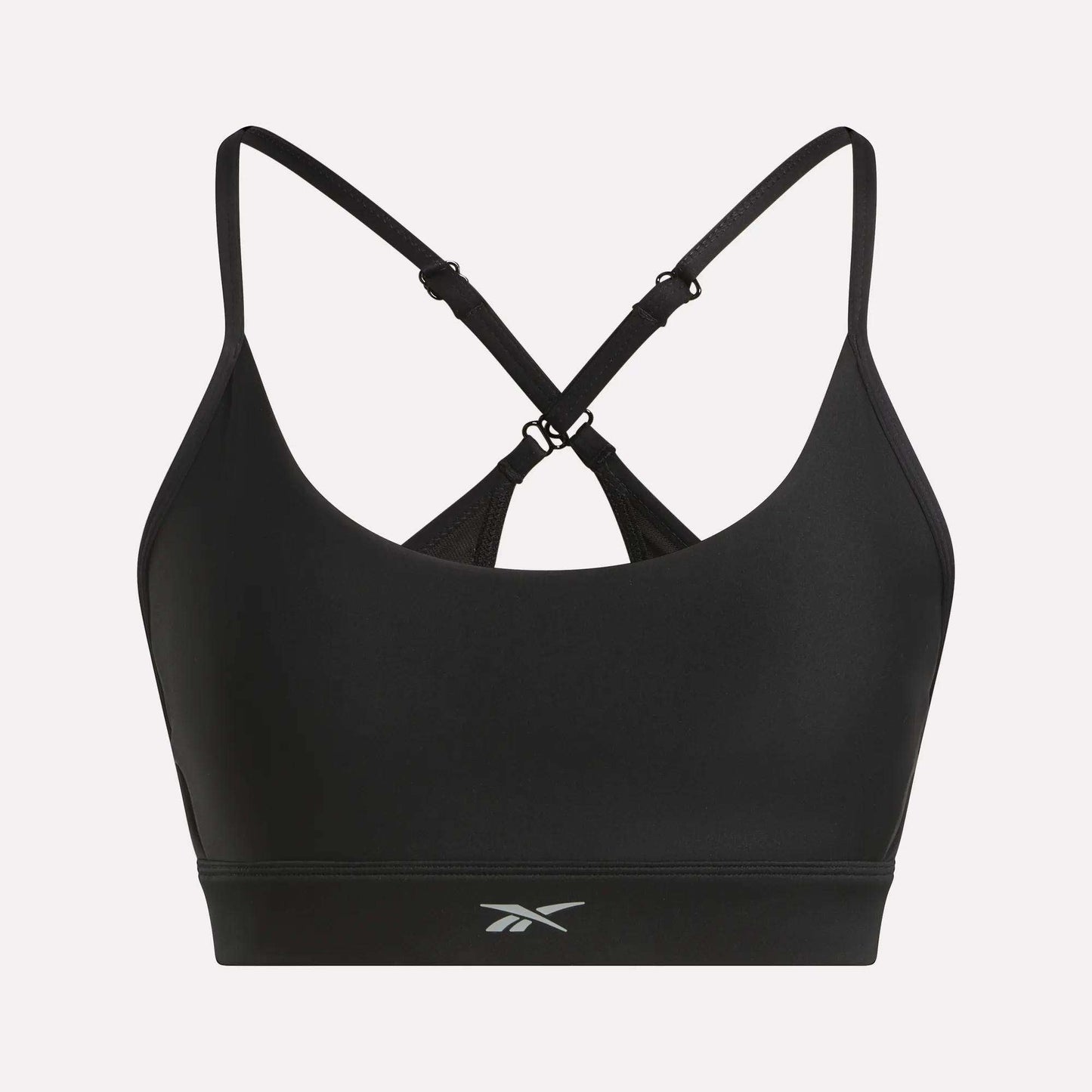 The Reebok Women's Lux Strappy Sports Bra features thin, adjustable crisscross straps, a small front logo, and delivers medium support with sweat-wicking comfort for your workouts.