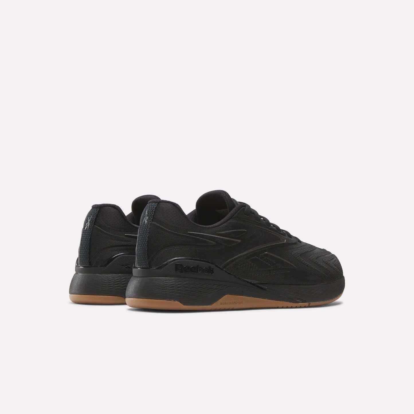 A pair of black Reebok Nano X5 Edge Training Shoes with gum soles is displayed from a rear-side angle on a white background, featuring Flexweave textured details and Reebok logos on the sides and heel.