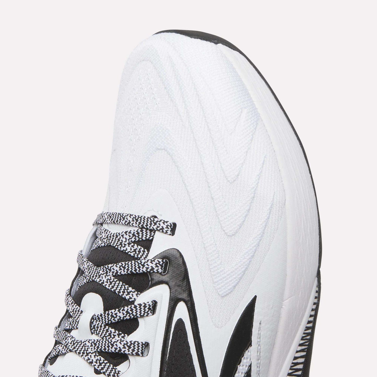 Close-up of the front and side of Reebok Nano X5 Edge Training Shoes, showing black accents, a wavy textured pattern, black-and-white laces, and part of the sole designed for optimal performance.