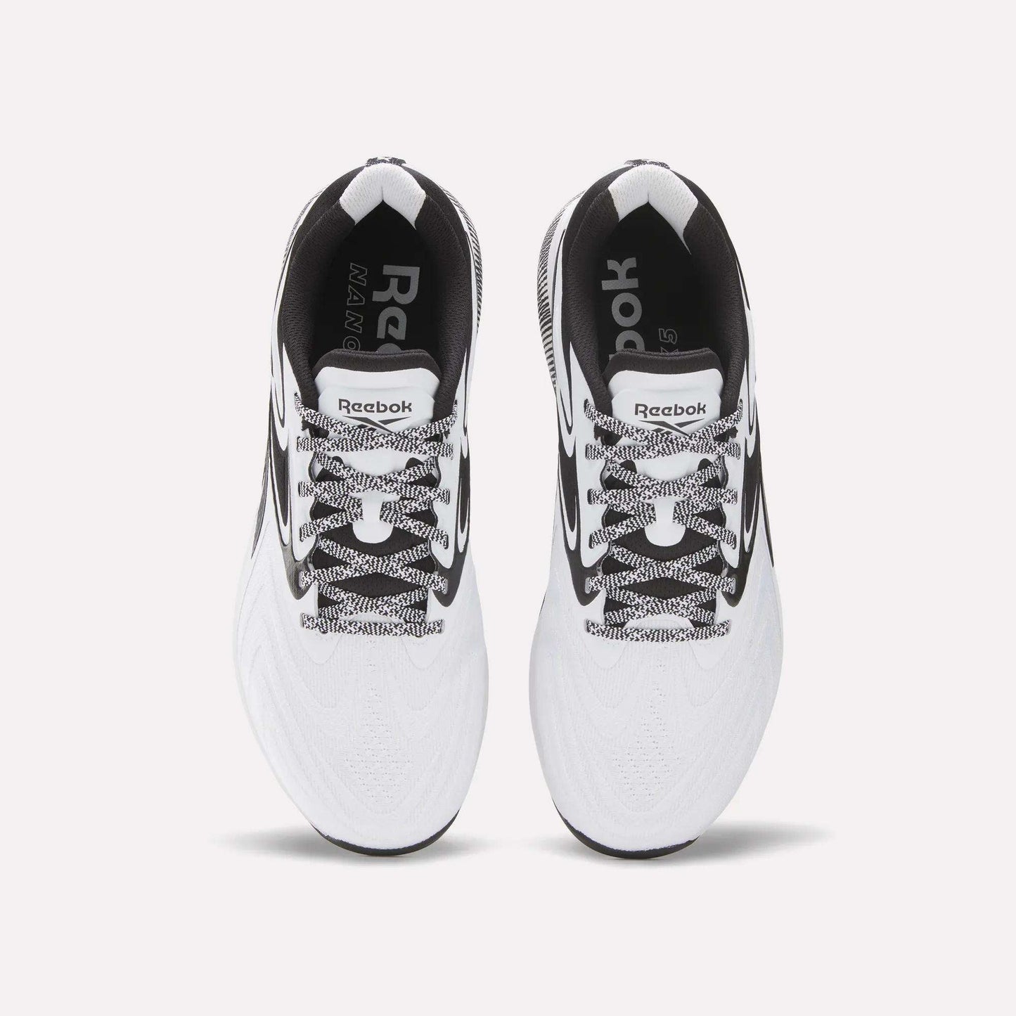 Top view of Reebok Nano X5 Edge Training Shoes in white with black accents, black-and-white laces, and visible Reebok logos on the insoles and tongue, set against a plain white background.