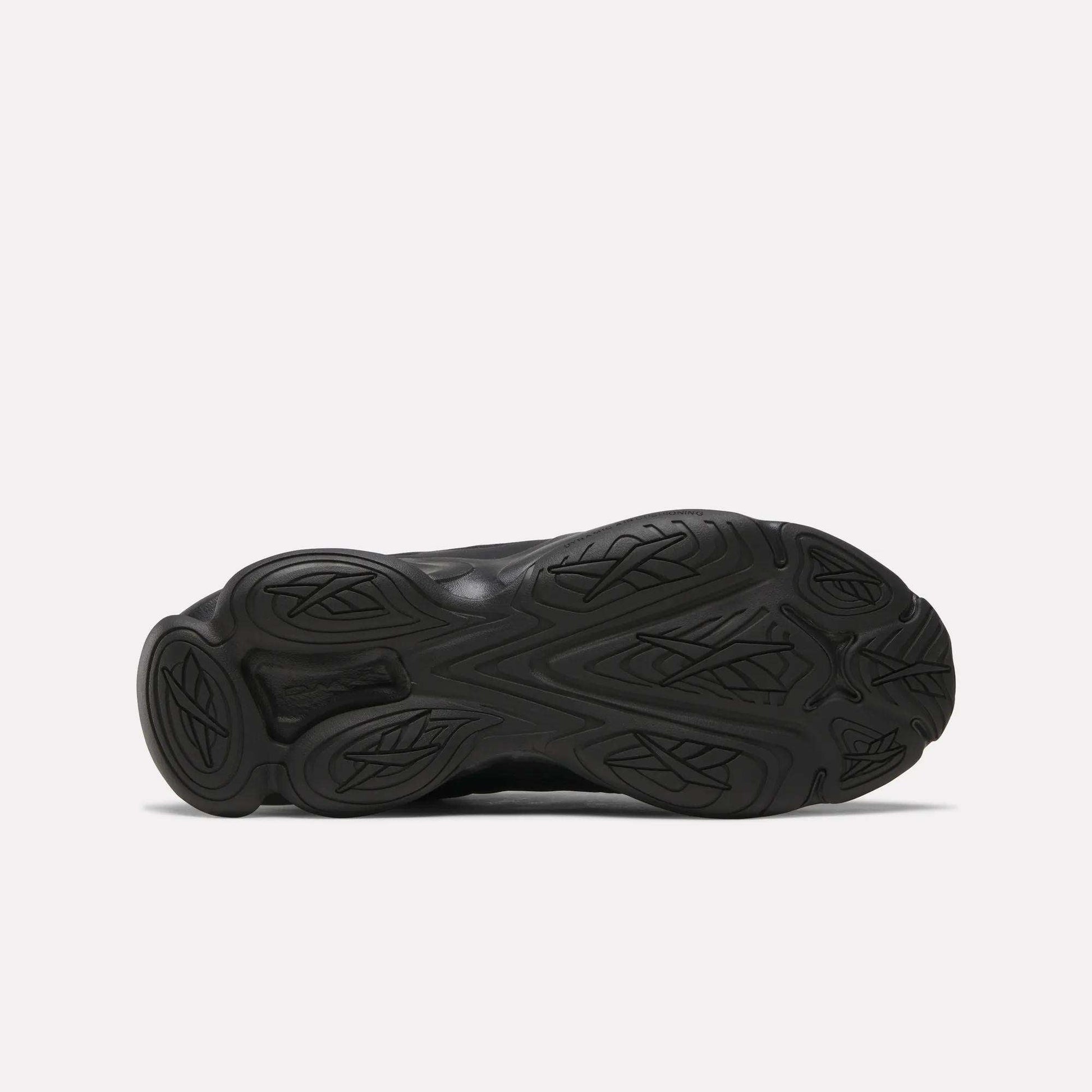 The image shows the black rubber outsole of the Reebok DMX Series 3000 Shoes, featuring DMX moving air technology and a wavy, textured tread pattern with decorative grooves visible on the sole.