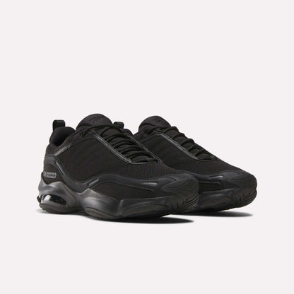 The Reebok DMX Series 3000 Shoes in black feature mesh uppers, thick rubber soles, subtle side branding, and DMX moving air technology for enhanced comfort—shown on a plain white background.