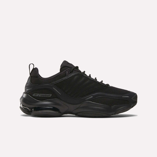 The Reebok DMX Series 3000 Shoes in black have a chunky sole, mesh and synthetic overlays, lace-up closure, and DMX moving air tech for comfort, shown in side view against a plain white background.