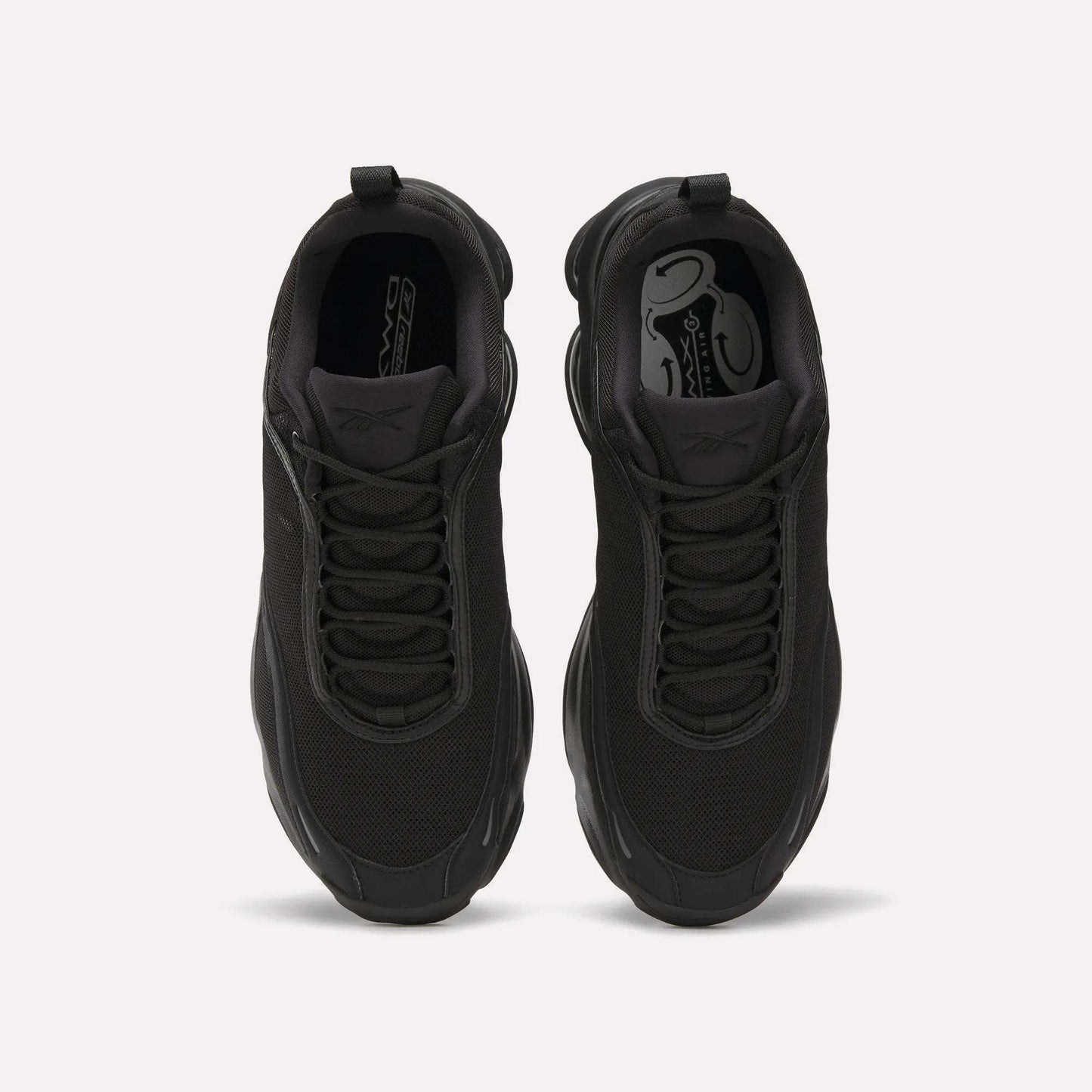 Top view of a pair of black Reebok DMX Series 3000 Shoes with mesh uppers, black laces, and thick soles featuring DMX moving air technology, placed side by side on a plain white background.
