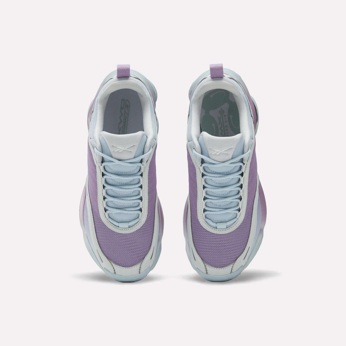 Top view of Reebok Women's DMX Series 3000 Training Shoes with light purple mesh uppers, white soles, and pale blue laces, featuring DMX 3 Technology for cushioned comfort—all side by side on a plain white background.