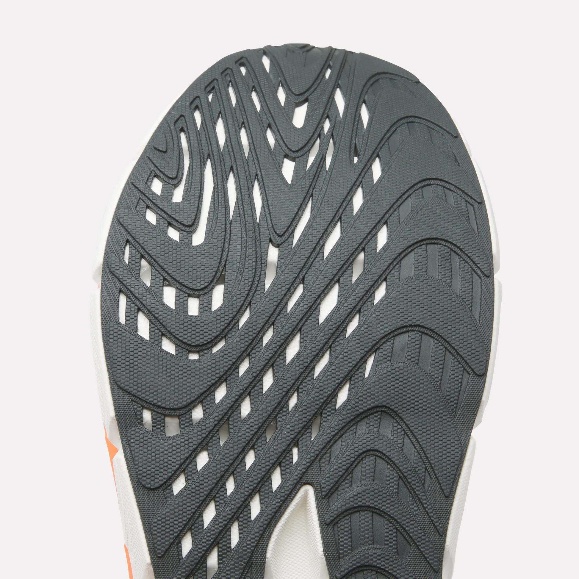 Close-up of a Reebok Men's FloatZig Double Running Shoe sole, showing its textured rubber with wavy grooves for traction—ideal for max-cushioned runs—all set against a plain, light background.
