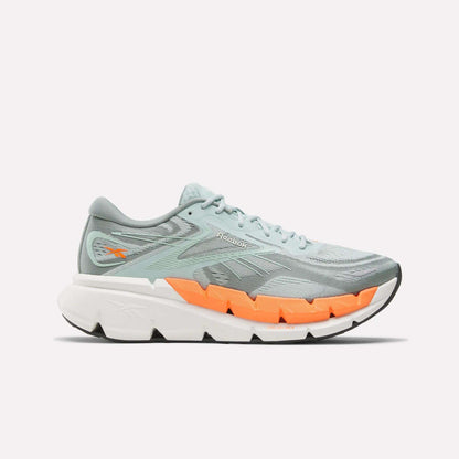 The Reebok Men's FloatZig Double Running Shoes are shown in profile, featuring light blue uppers with an orange accent above a thick white sole, designed for max-cushioned miles, against a plain white background.