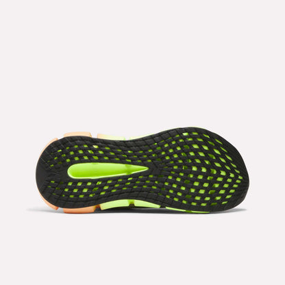 The image shows the bottom view of the Reebok Women's FloatZig 2 Running Shoes, featuring a black outsole with a grid-like neon green pattern, orange accents at heel and toe, and Superfloat+ cushioning for extra comfort.