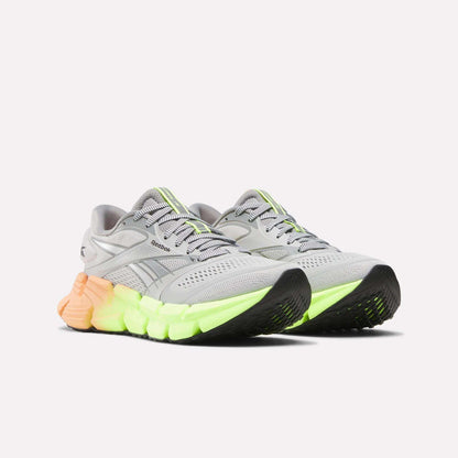 A pair of Women's FloatZig 2 Running Shoes by Reebok in gray with neon green and yellow accents, Superfloat+ cushioning, a chunky textured sole, and mesh details, shown on a white background.