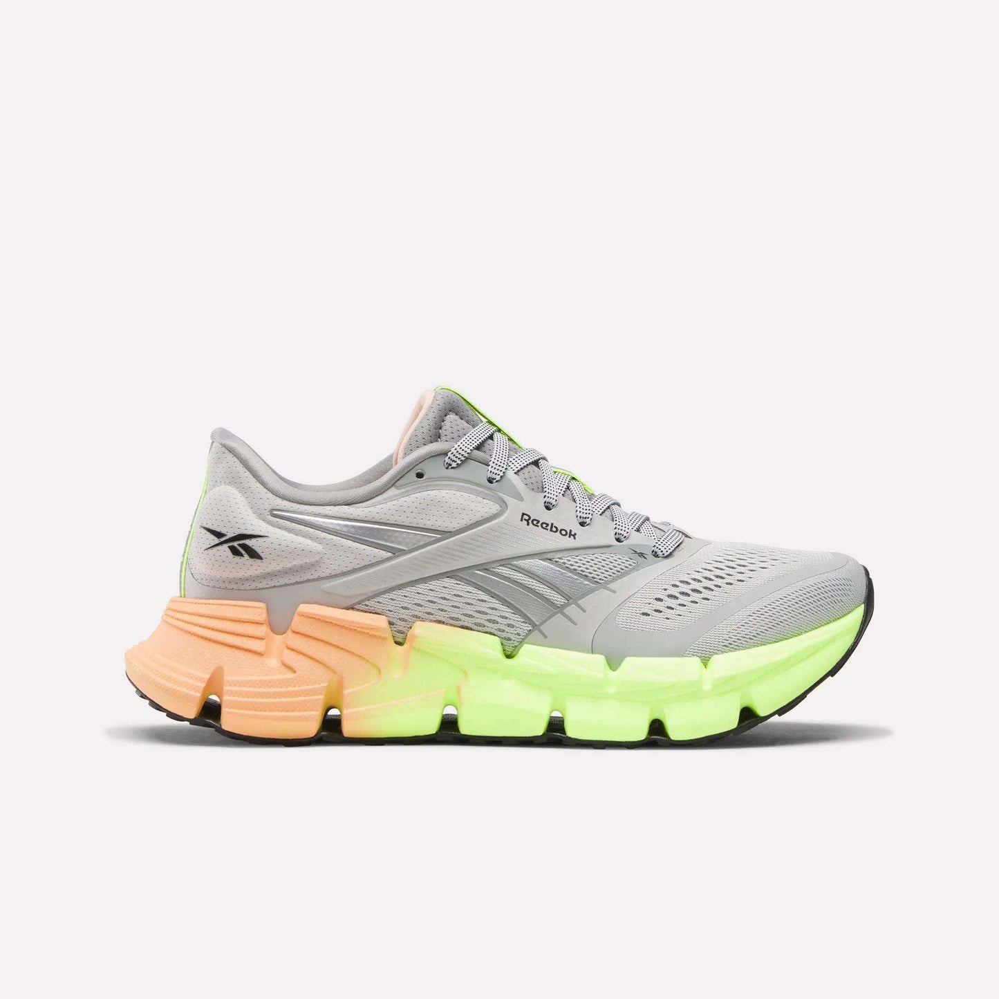The Reebok Women's FloatZig 2 Running Shoes feature a gray mesh upper, Superfloat+ cushioning, a neon green front sole, and an orange heel—delivering comfort and style, shown on a plain white background.