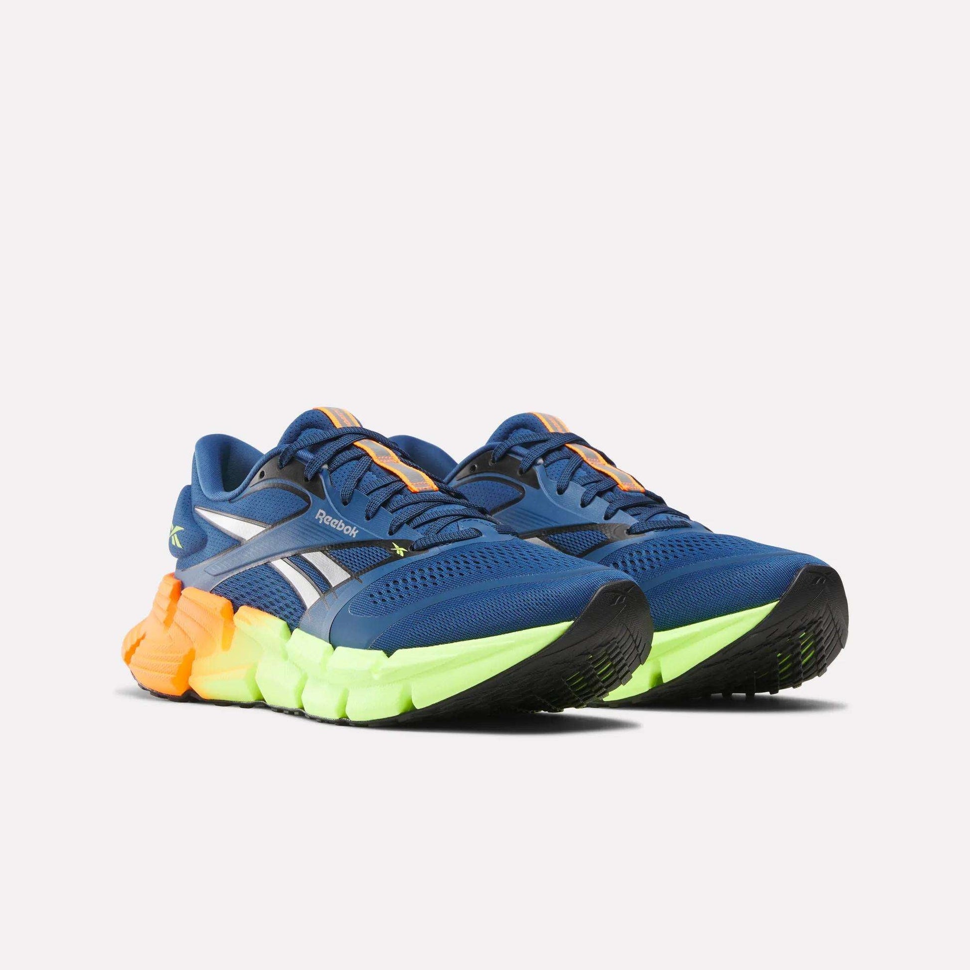 Men's FloatZig 2 Running Shoes by Reebok in blue with silver accents, neon yellow soles, Superfloat+ cushioning, orange heel details, and black outsoles, shown against a plain white background.