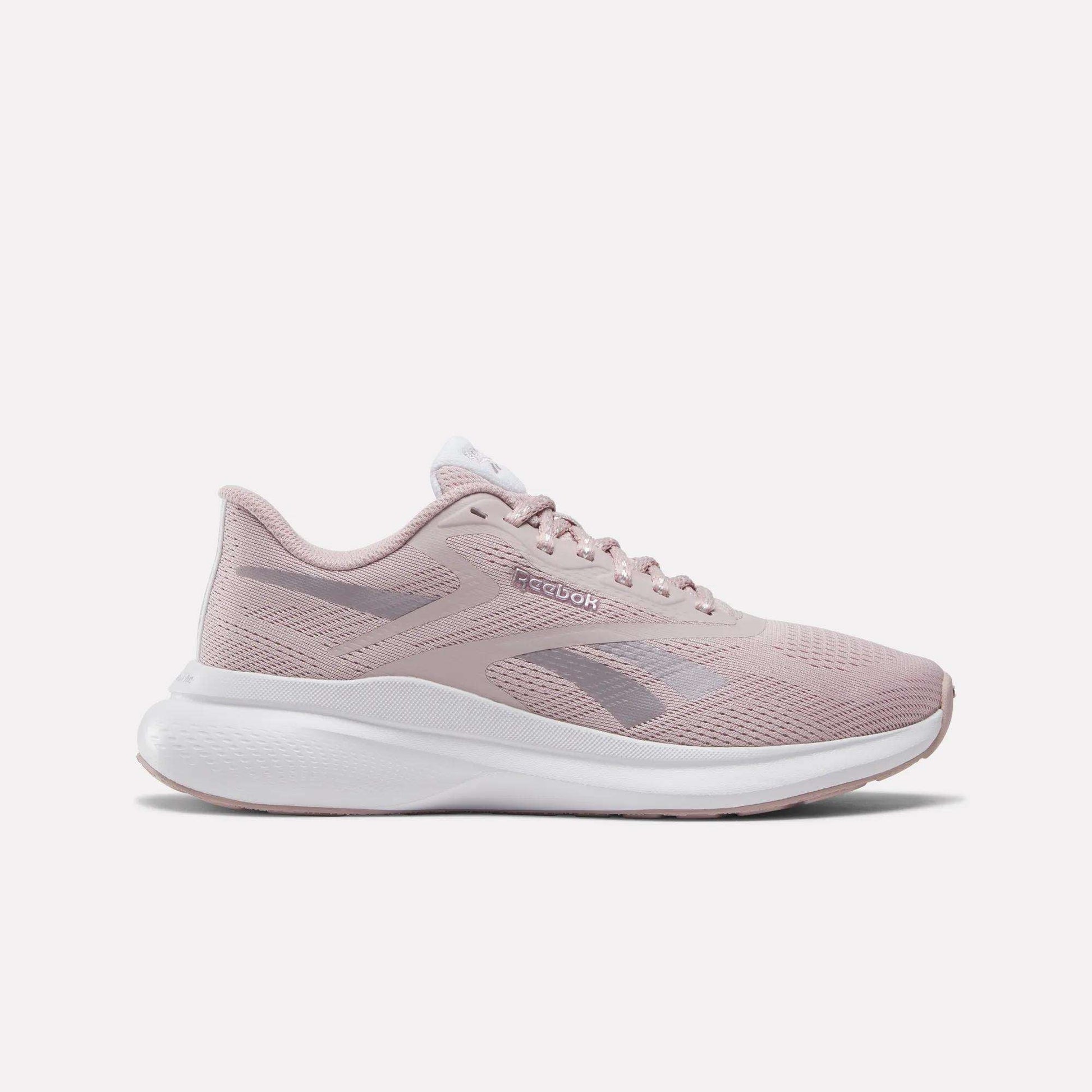 The Reebok Women's Energen Run 4 Running Shoes in Muted Mauve/White feature a breathable mesh upper, lace-up closure, white sole, and subtle Reebok logos on the side and tongue.