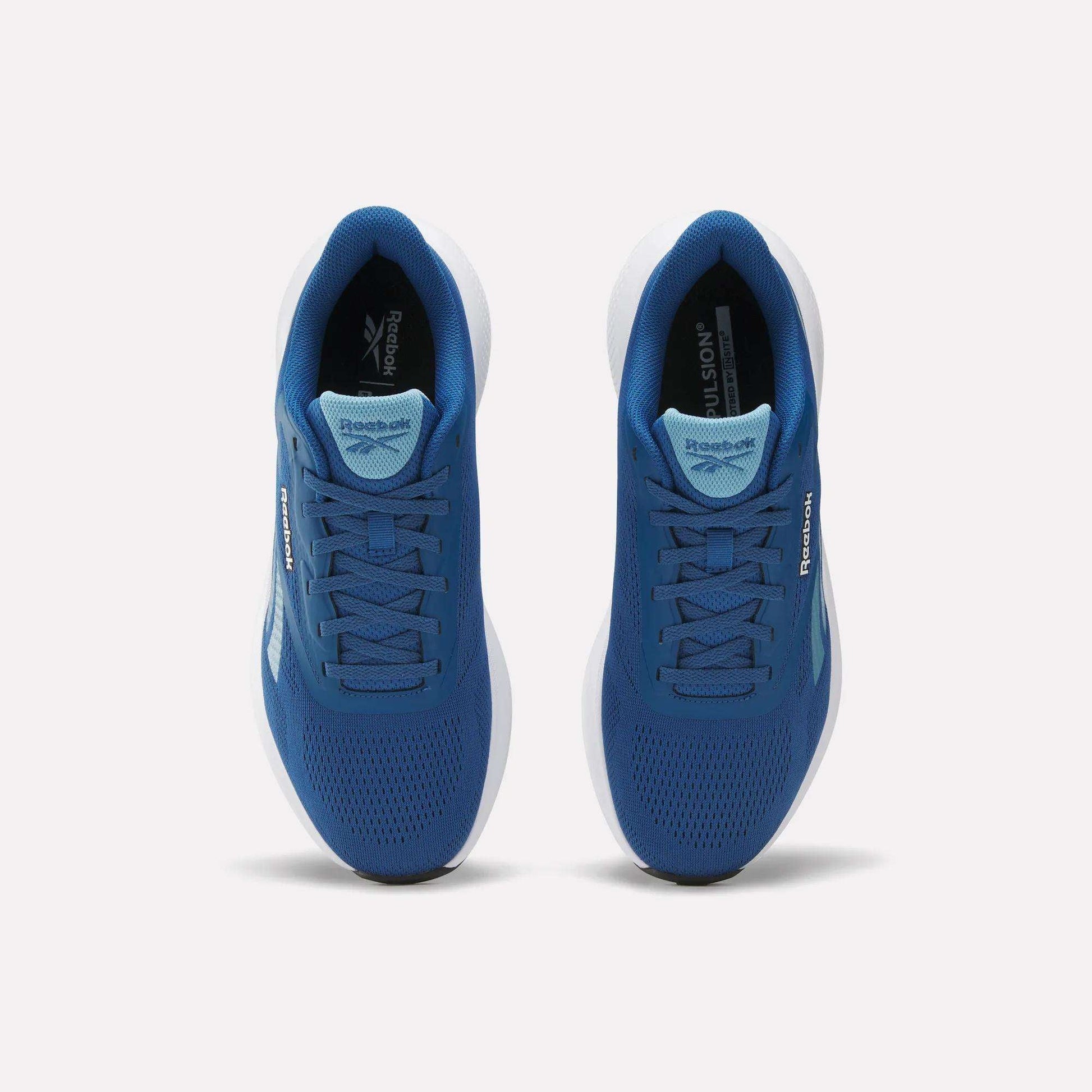 Top view of Reebok Men's Energen Run 4 Running Shoes with breathable mesh uppers, white soles, and visible Reebok logos on sides and tongues, shown side by side on a plain light background.