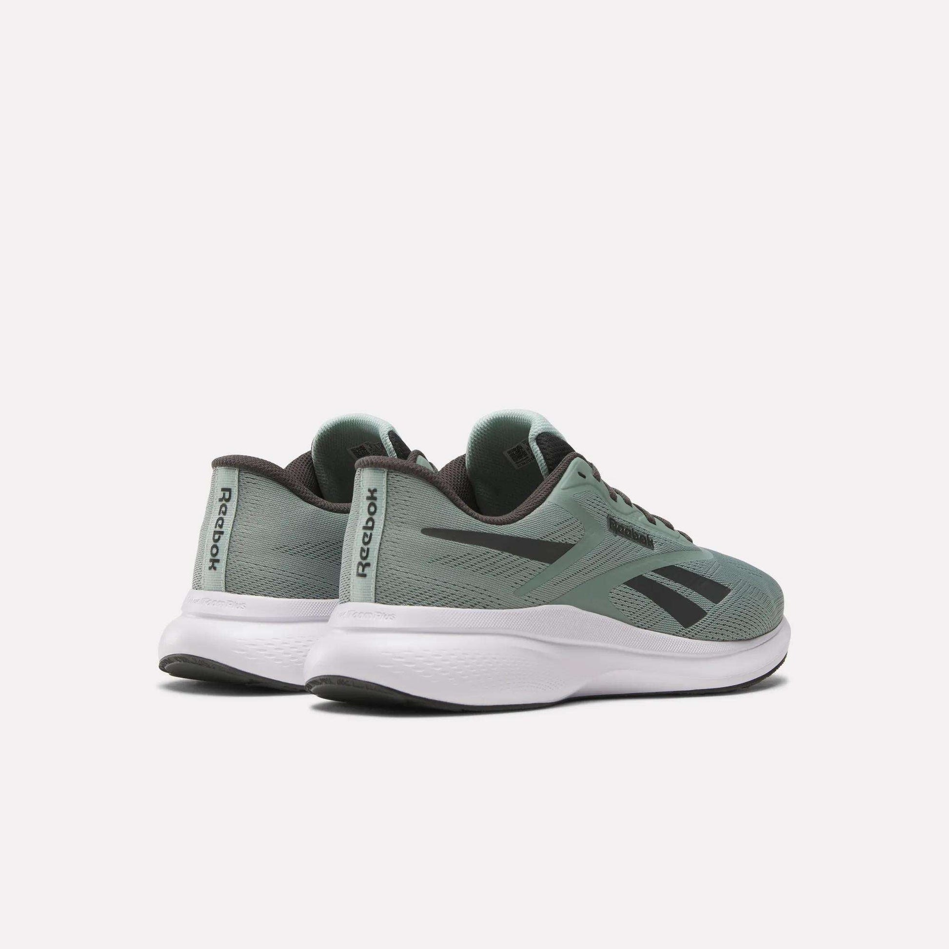 A pair of Men's Energen Run 4 Running Shoes by Reebok in green with black accents and white soles, featuring a lightweight design and breathable mesh upper, are shown on a light background at an angle to display side and back details.