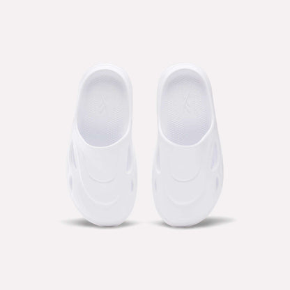 The Reebok DMX Recovery Mules are white slip-on shoes featuring a futuristic design with oval side cutouts, crafted from molded EVA, shown from above on a plain light background.