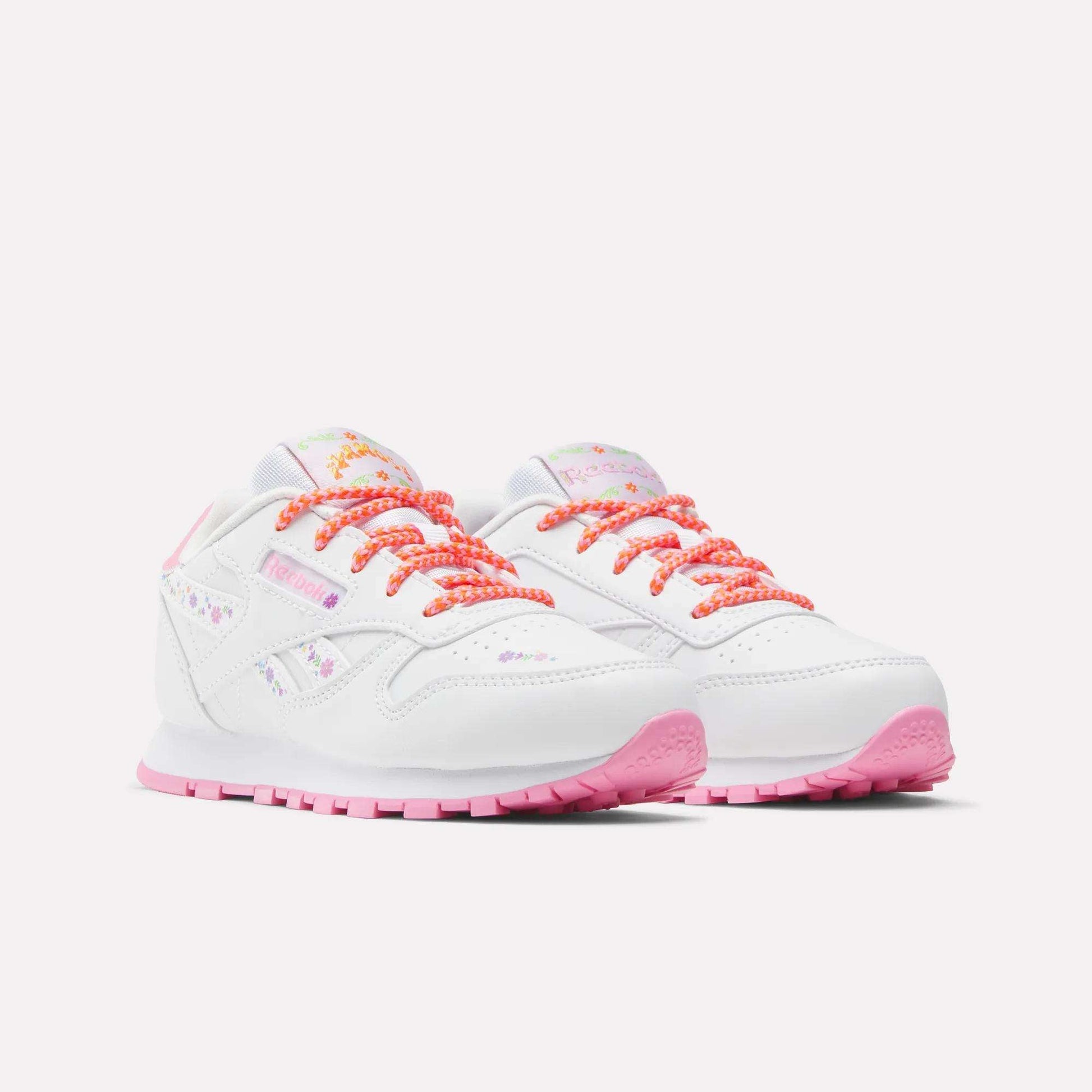 Reebok x DORA Classic Leather Shoes for little kids feature white leather, pink soles, patterned laces, and pastel floral accents—perfect comfy Reebok sneakers for playful adventures.
