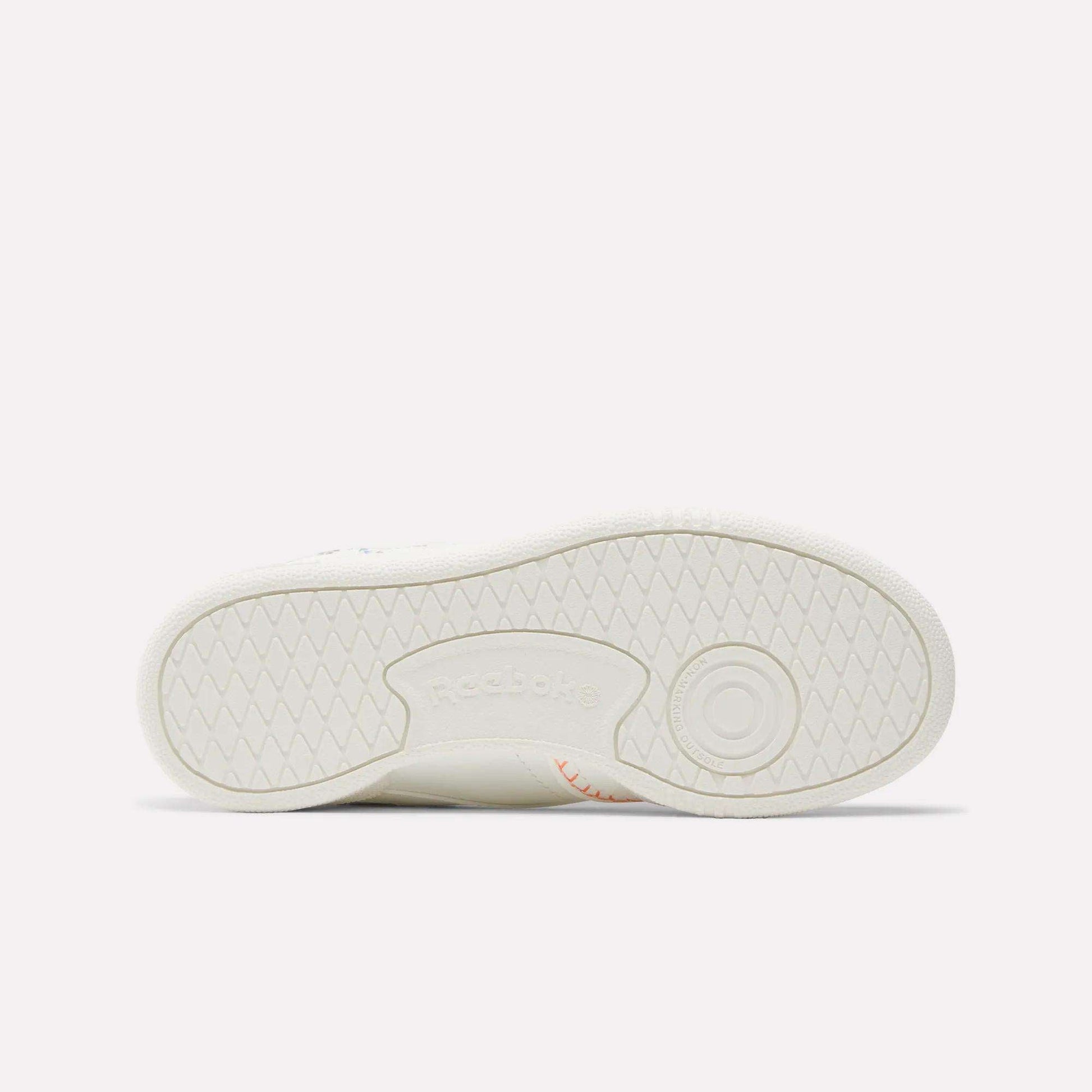 The image shows the sole of the Reebok x DORA Club C Shoes for little kids, laid flat to display the tread pattern and an embossed Reebok logo at the center.