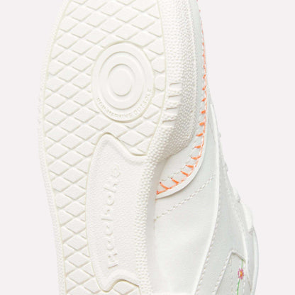 Close-up of the sole on Reebok x DORA Club C Shoes for little kids, showing textured grip, circular pattern, orange stitching, and a hint of a floral design on the upper.
