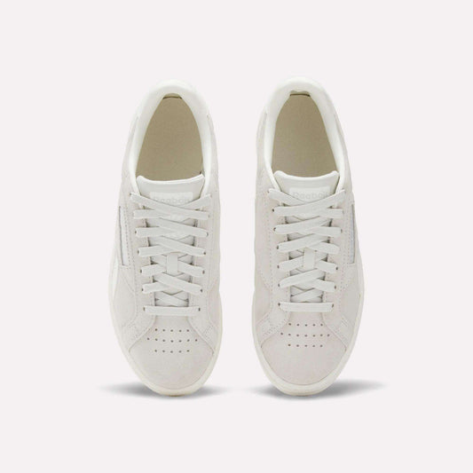 A pair of Women's Club C Grounds UK Shoes by Reebok, shown from above with visible laces and perforated toe on a plain light background—a timeless choice for women’s footwear.