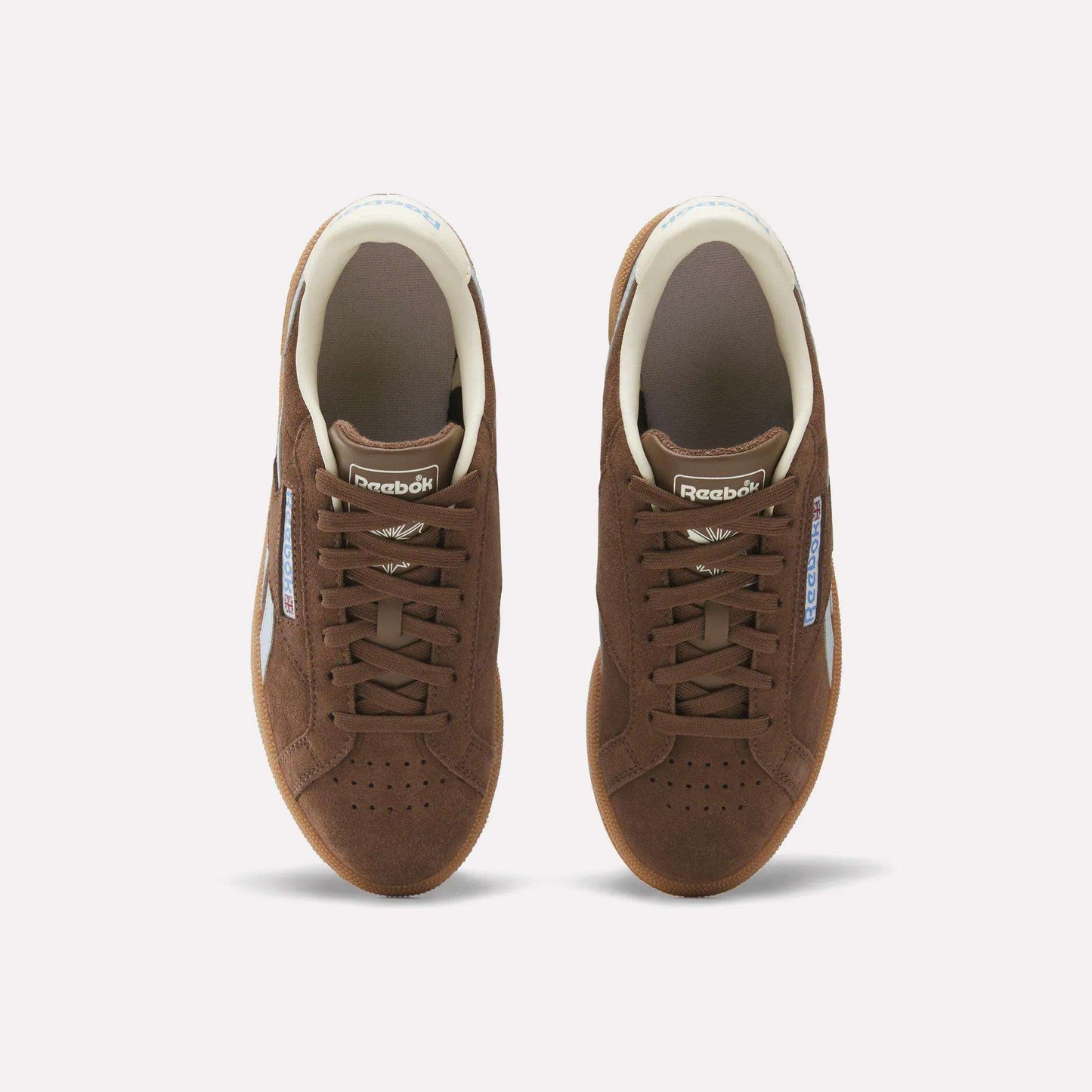 A top-down view of Reebok Women's Club C Grounds UK Shoes in brown, featuring laces, perforated toes, and white side logo accents against a plain white background.