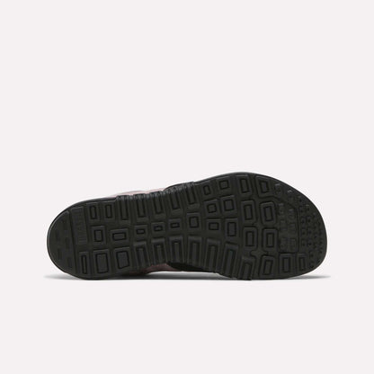 The image displays the black rubber sole of Reebok Women's Nano 2.0 Training Shoes, featuring a geometric tread pattern with squares and rectangles. The shoe is shown sole up on a plain light background—ideal for functional fitness.