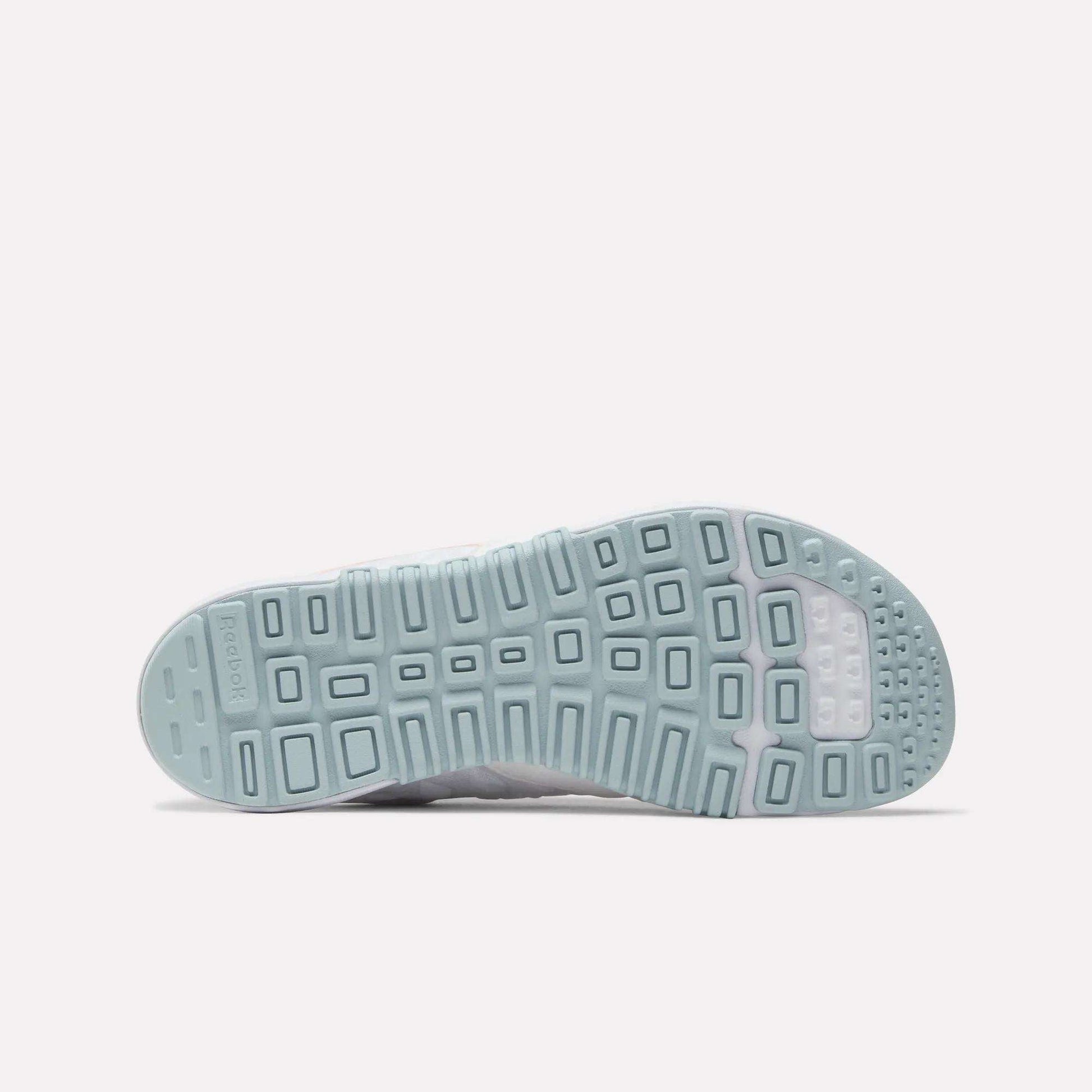 The image displays the light blue outsole of the Reebok Women's Nano 2.0 Training Shoes, featuring a geometric tread pattern with rectangular and square shapes for traction, and the Reebok logo on the left side.