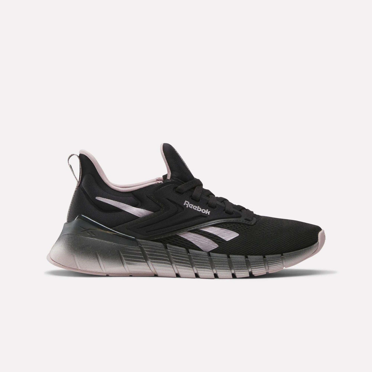 The Women's Nano Gym Training Shoes by Reebok feature a black design with light pink and white accents, a chunky gradient sole, and a low-top profile—ideal as versatile workout shoes for any fitness routine.