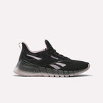The Women's Nano Gym Training Shoes by Reebok feature a black design with light pink and white accents, a chunky gradient sole, and a low-top profile—ideal as versatile workout shoes for any fitness routine.
