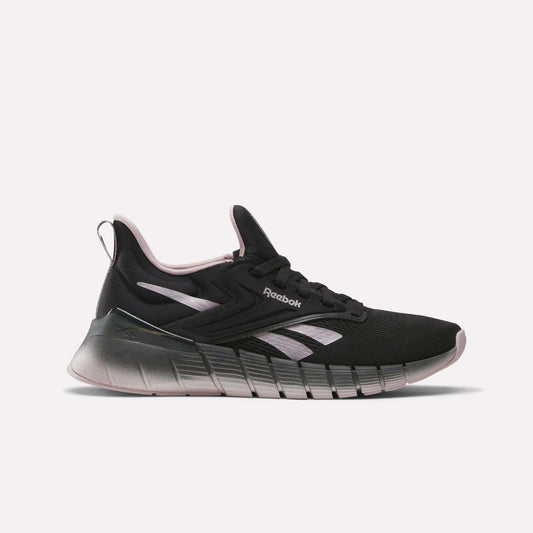 The Women's Nano Gym Training Shoes by Reebok feature a black design with light pink and white accents, a chunky gradient sole, and a low-top profile—ideal as versatile workout shoes for any fitness routine.