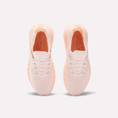 The Women's Nano Gym Training Shoes from Reebok are pink and white, ideal for your next workout.