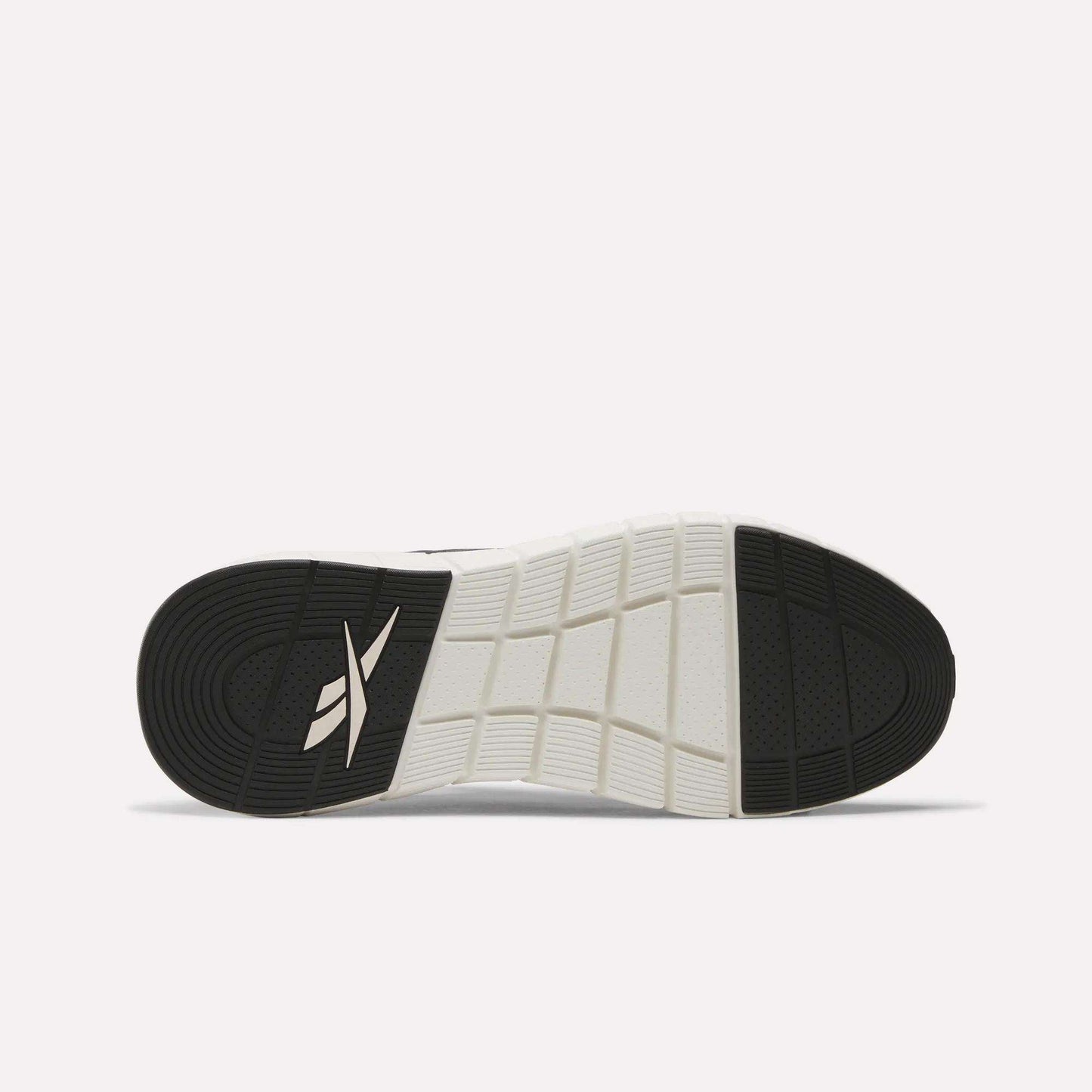 The image shows the black and white rubber outsole of Reebok Men's Nano Gym Training Shoes, featuring a grid pattern and the Reebok logo near the heel.