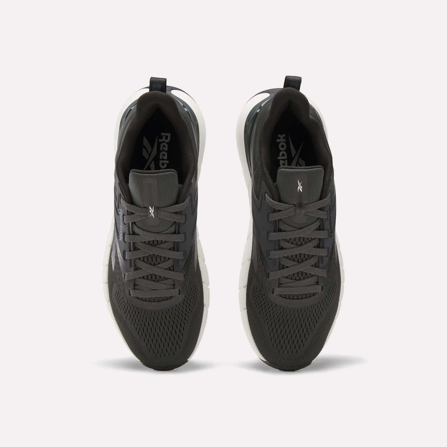 A pair of Reebok Men's Nano Gym Training Shoes in dark gray, shown from above with mesh uppers, black laces, and white soles—perfect for training, displayed on a plain white background.