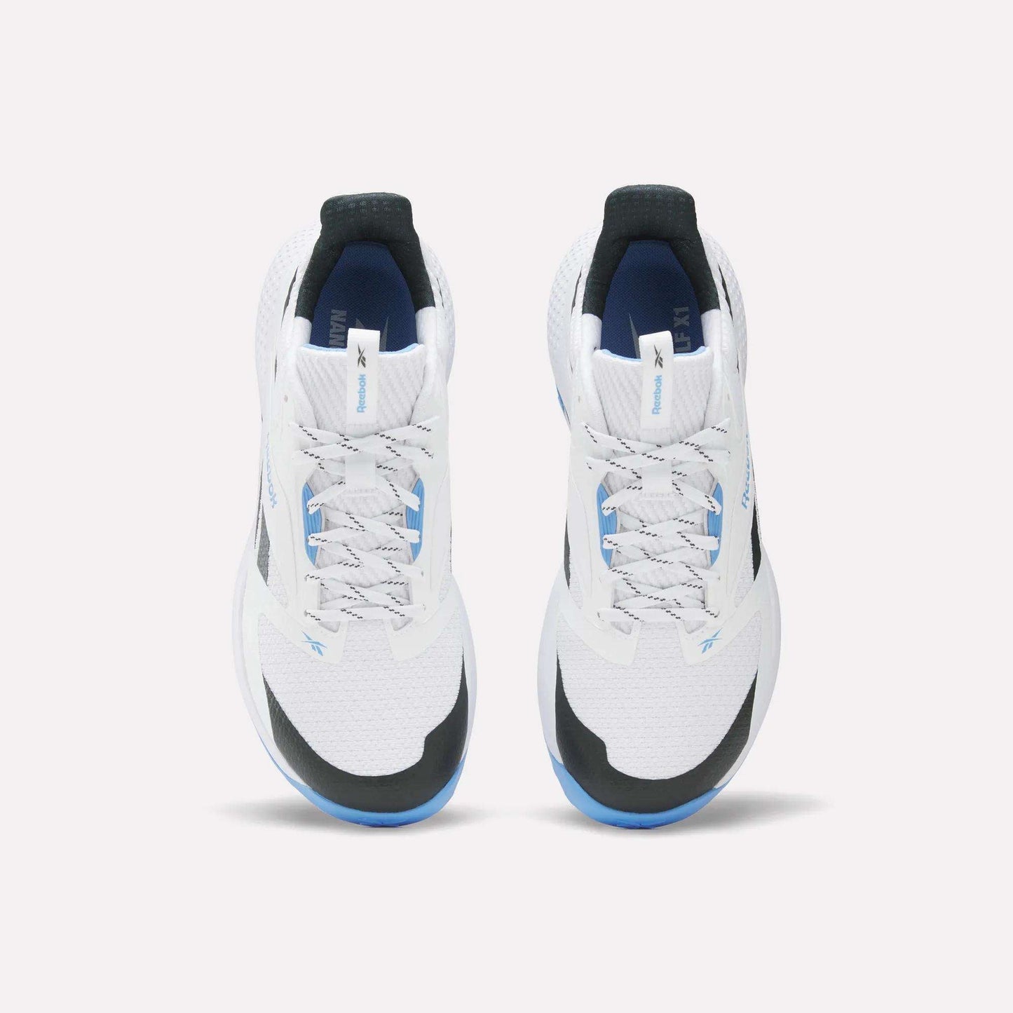 The Reebok Nano Golf Shoes are white athletic sneakers with black and blue accents, seen from above on a white background. They feature white laces, a FlexWeave mesh upper for modern style, and enhanced performance foam for comfort.