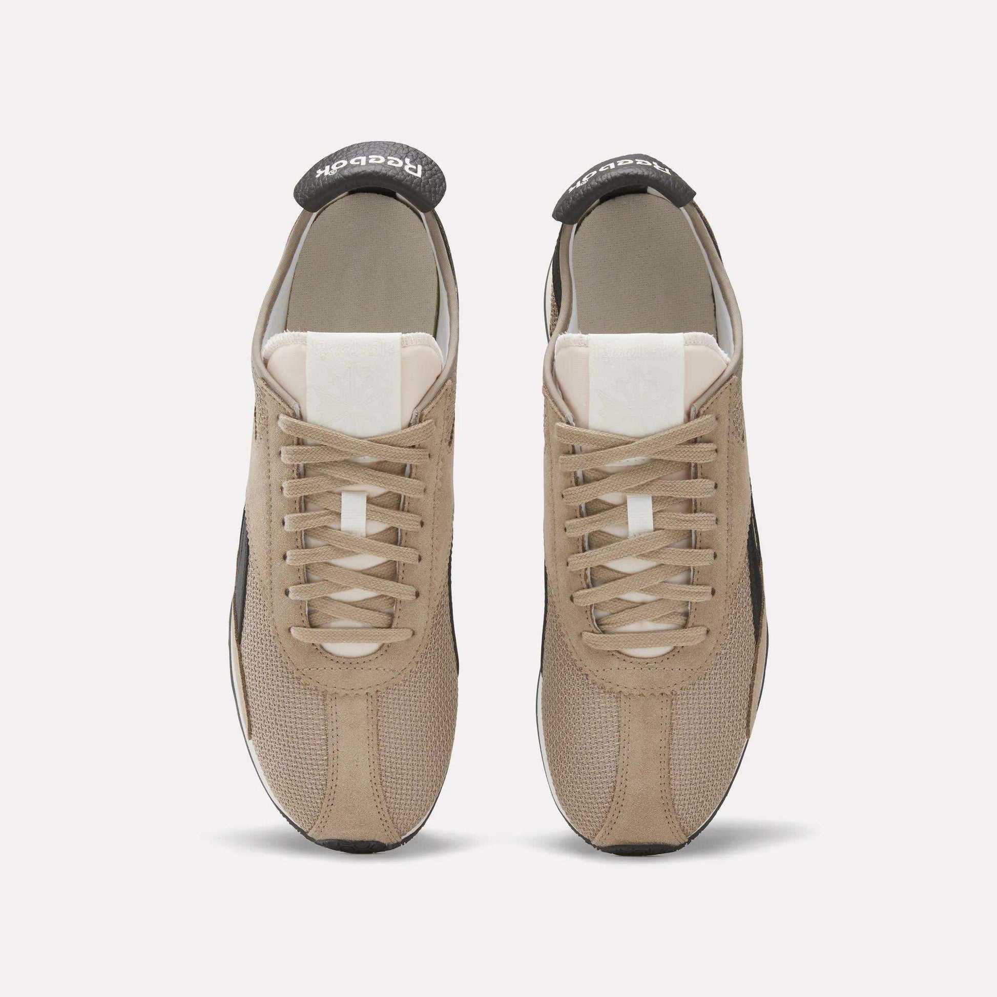 A pair of beige Reebok R400 Shoes shown from above, featuring white tongues, beige laces, and black Reebok branding on the heel tabs—stylish vintage sneakers on a plain light background.