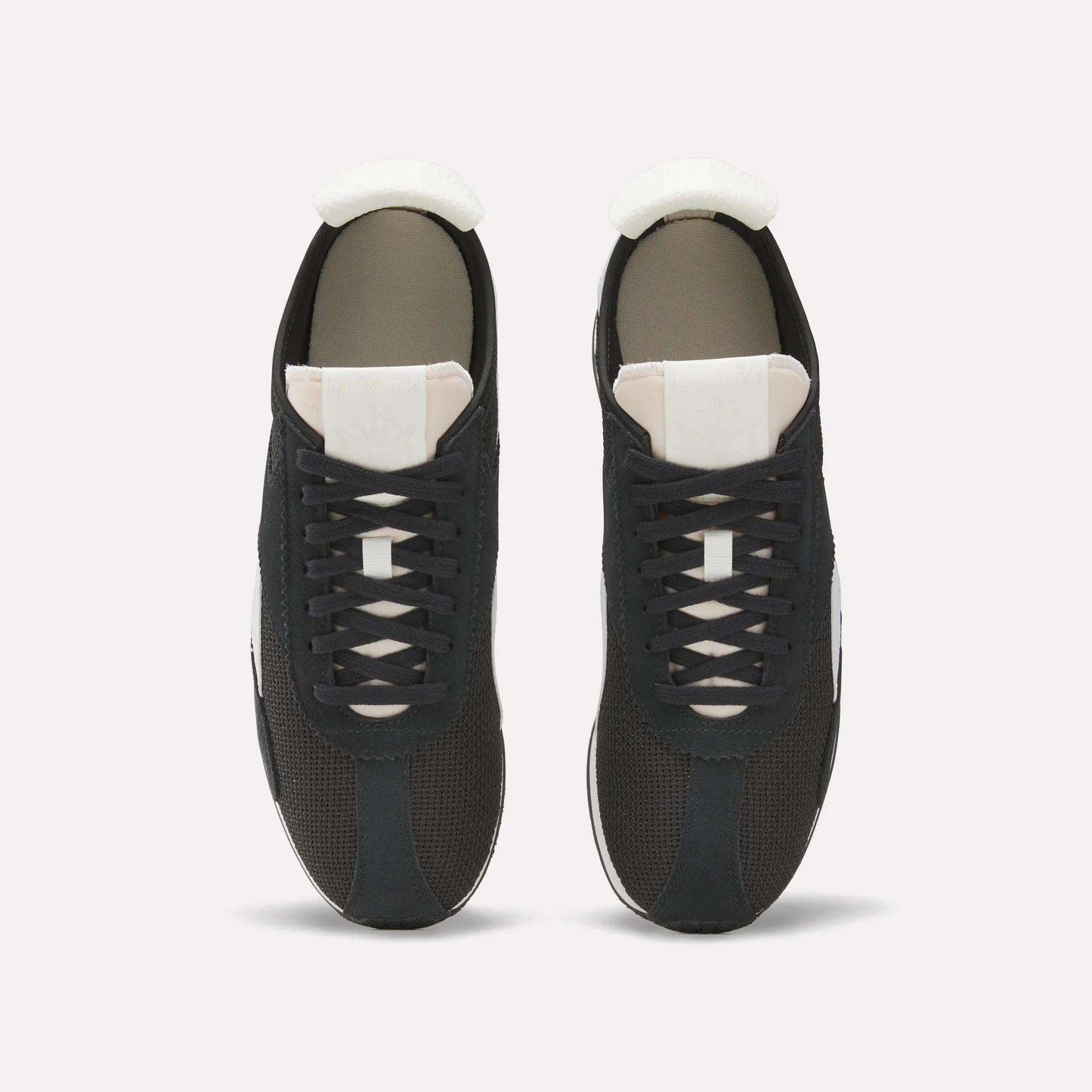 Top view of a pair of Reebok R400 Shoes, featuring black retro design with white tongues, white soles, and black laces, placed side by side on a plain white background.