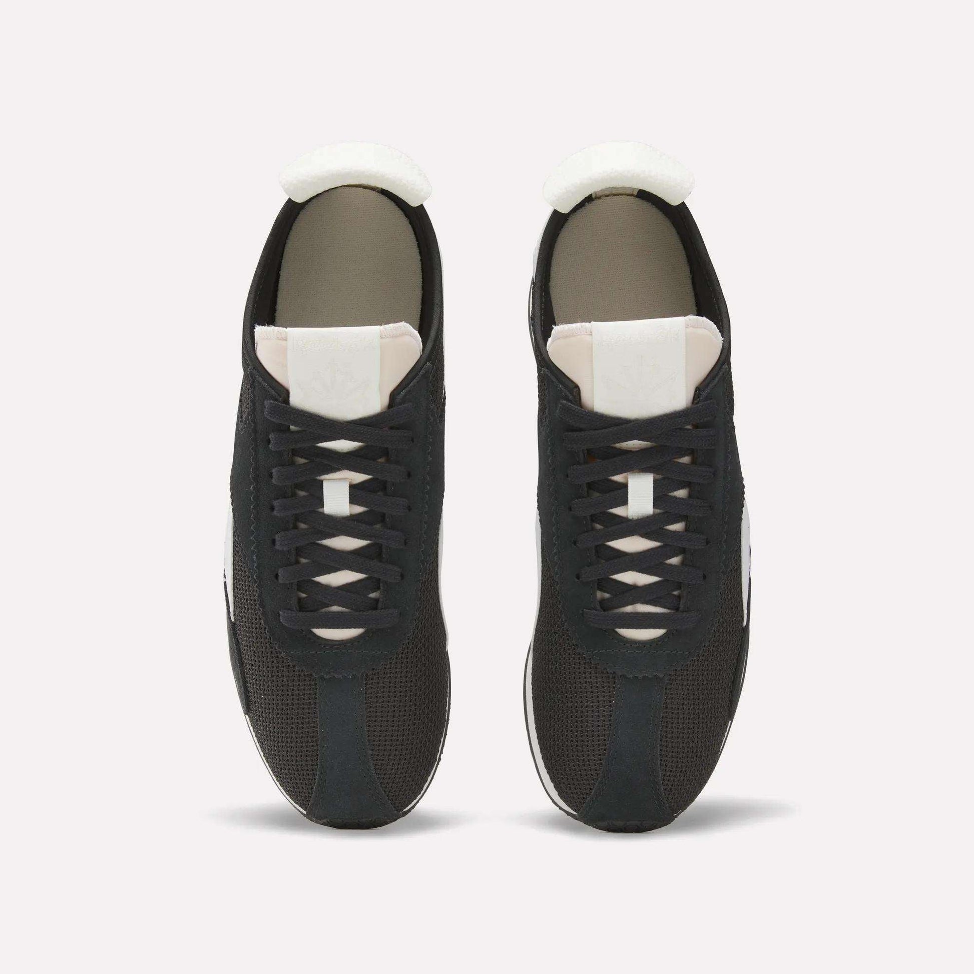 Top view of a pair of Reebok R400 Shoes, featuring black retro design with white tongues, white soles, and black laces, placed side by side on a plain white background.