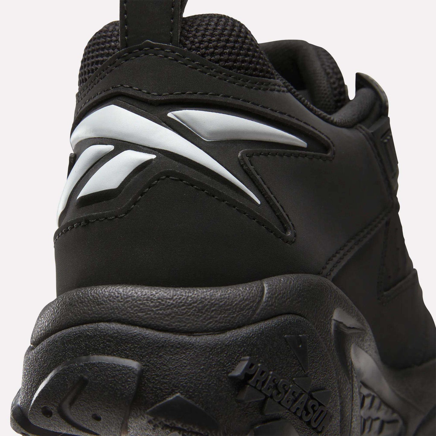 Close-up of the heel and sole of the Reebok Brutus Low Shoes in black, featuring a white Reebok logo and textured outsole—ideal for adding street-ready style to your outfit.
