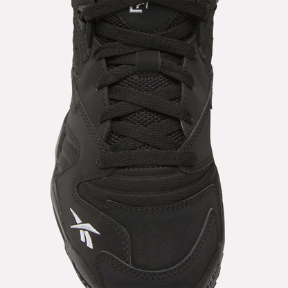 Close-up of the Brutus Low Shoes by Reebok in black, featuring black laces, mesh and leather upper, and a white logo on the toe—perfect for adding street-ready style to your look.
