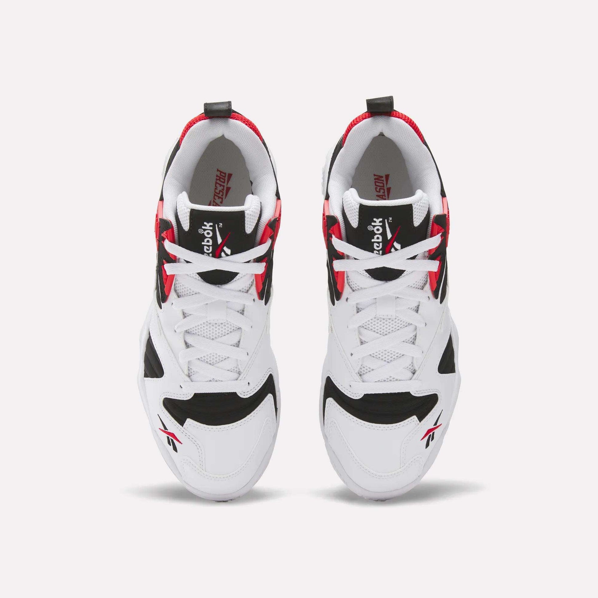 A pair of Brutus Low Shoes by Reebok seen from above, featuring a white base with black and red accents, white laces, and Reebok logos on the tongue and side—ideal for street-ready style.
