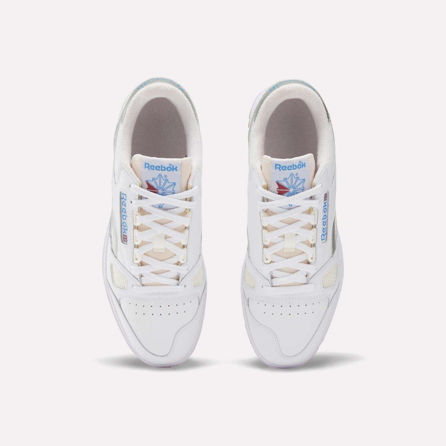 Top view of Reebok Defiance 88 Shoes in white leather with beige soles, light tan laces, blue Reebok branding, and a blue and pink tongue graphic, finished with subtle metallic details for a stylish look.