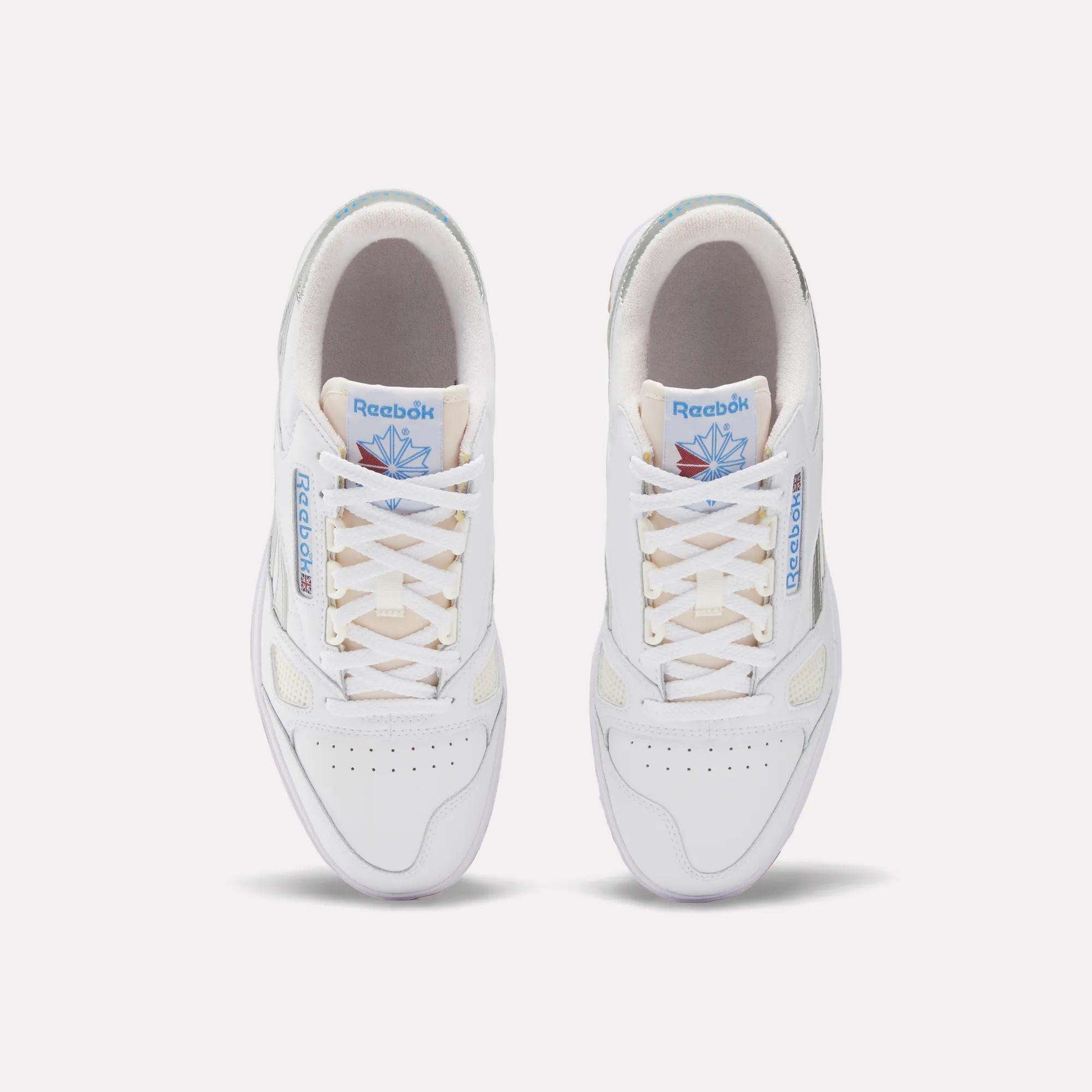 Top view of Reebok Defiance 88 Shoes in white leather with beige soles, light tan laces, blue Reebok branding, and a blue and pink tongue graphic, finished with subtle metallic details for a stylish look.