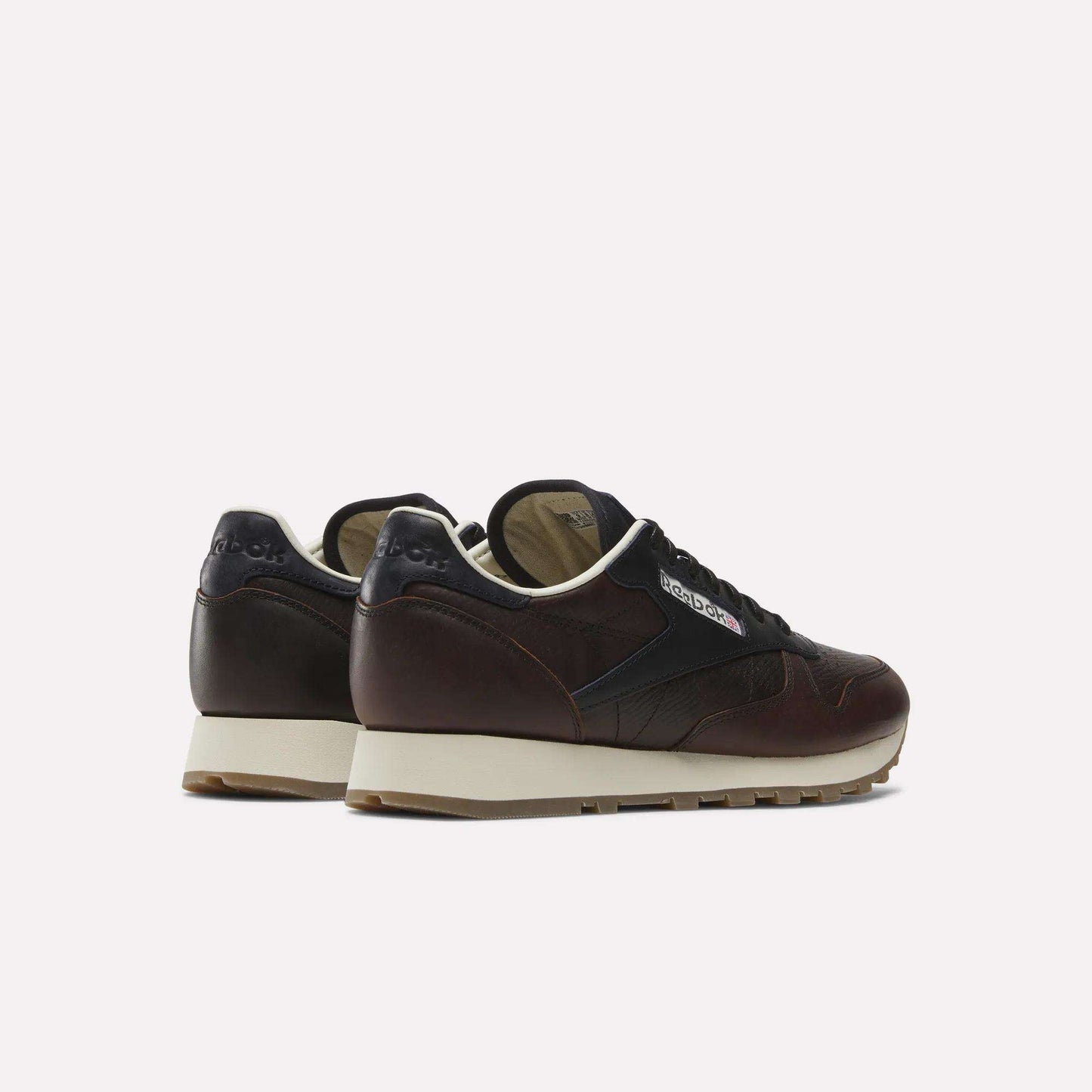 The Reebok x C.F. Stead Classic Leather Shoes, featuring dark brown and black luxe leather with beige soles, are displayed on a white background and shown from the back and side.