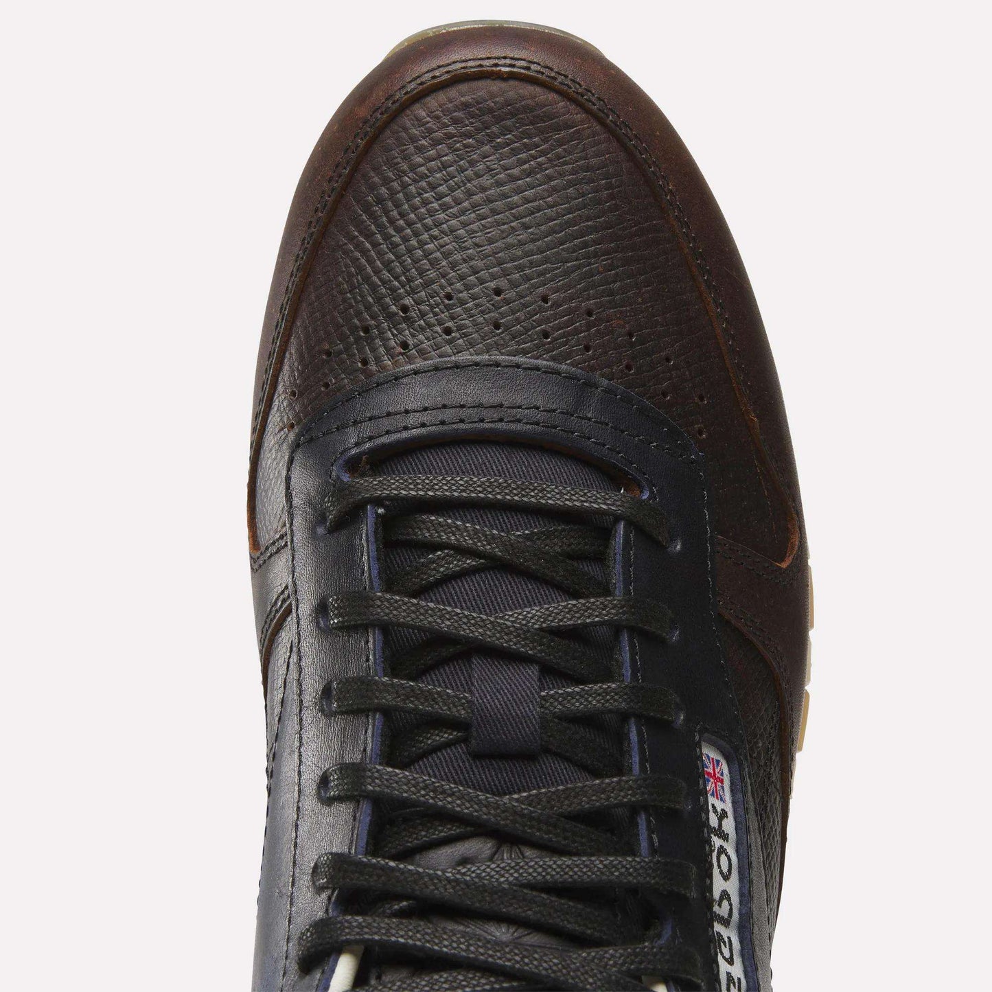 Top view of the Reebok x C.F. Stead Classic Leather Shoes in dark brown and black, featuring a textured full-grain leather upper, black laces, and a visible Reebok logo with the British flag near the tongue.