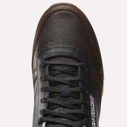Top view of the Reebok x C.F. Stead Classic Leather Shoes in dark brown and black, featuring a textured full-grain leather upper, black laces, and a visible Reebok logo with the British flag near the tongue.