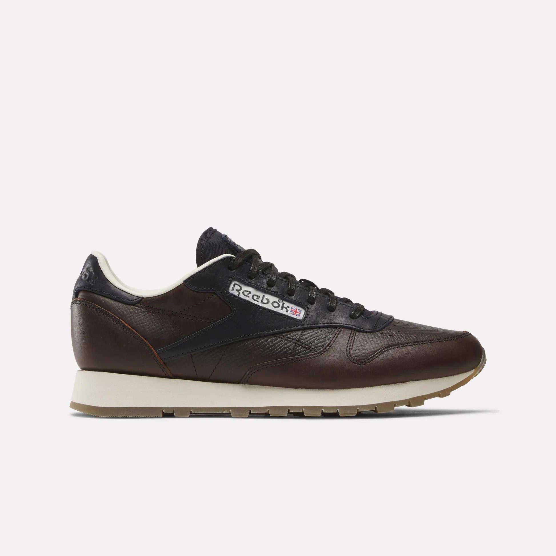 Side view of the Reebok x C.F. Stead Classic Leather Shoes in dark brown full-grain leather, featuring black laces, a beige midsole, and a brown rubber outsole. The Reebok logo and Union Jack are visible on the side.