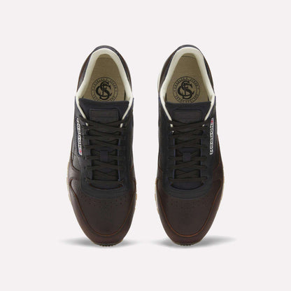 The Reebok x C.F. Stead Classic Leather Shoes feature dark brown luxe leather, black laces, white inner lining, and Reebok logos on the tongue and side, shown from above against a plain white background.