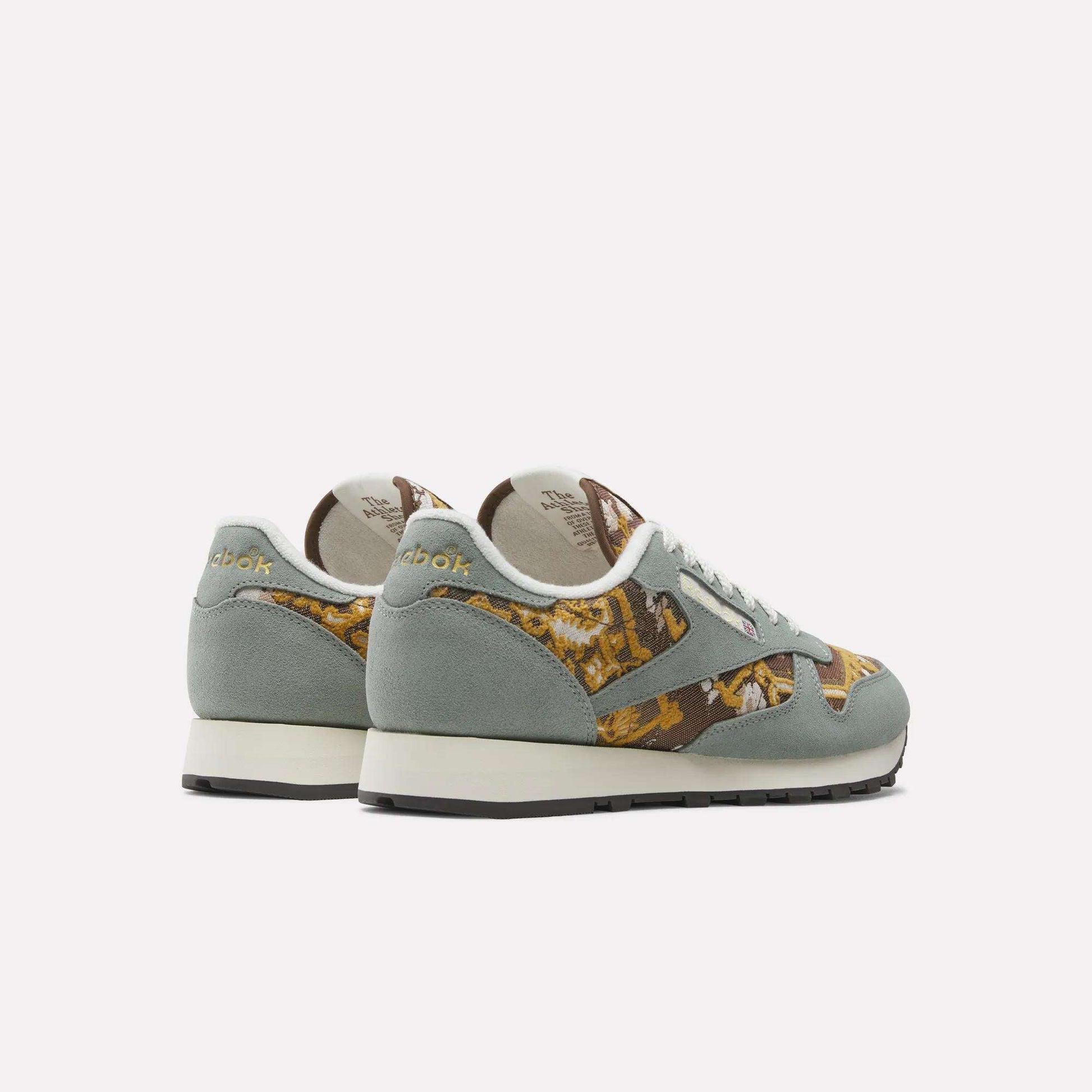 A pair of Reebok Classic Leather 1983 Vintage Shoes with light green suede and multicolored brown, yellow, and white patterned fabric sides, displayed on a white background at an angle highlighting the heels.