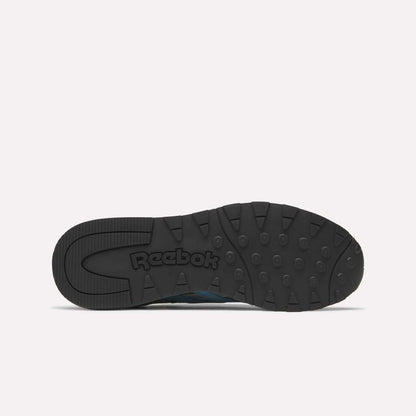 The image displays the black rubber outsole of Reebok Classic Nylon 89 Shoes from below, featuring circular tread patterns, a cushioned midsole, and an embossed Reebok logo at the center against a plain white background.
