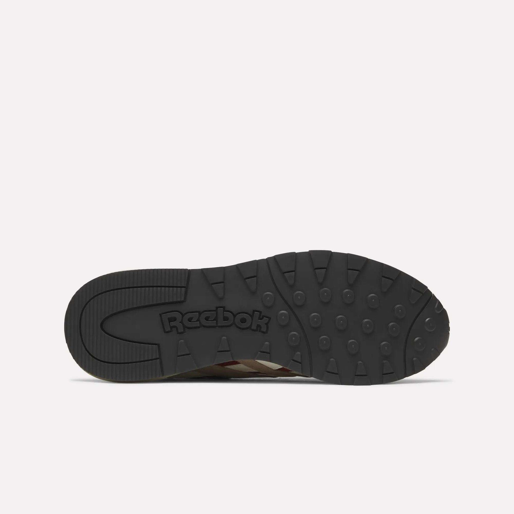 The image displays the black rubber outsole of a Reebok Classic Nylon 89 Shoe, viewed from below. It features circular grips, embossed Reebok branding near the heel, and suggests a cushioned midsole typical of classic running shoes.