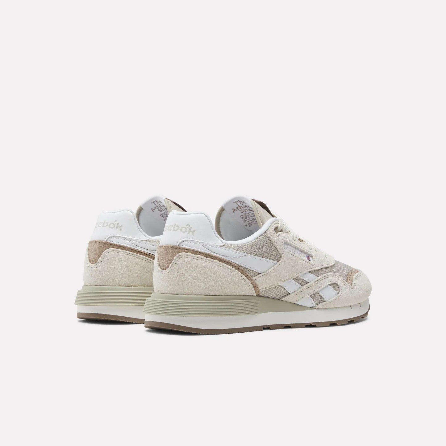 A pair of Reebok Classic Nylon 89 Shoes in beige and white, with suede and mesh panels, cushioned midsole, Reebok logo, and retro design, shown from the back and side on a white background.